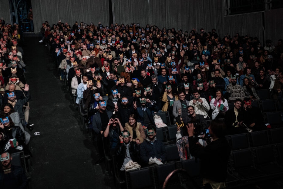 Plateia lotada em sessão do Olhar de Cinema, com óculos personalizados do festival